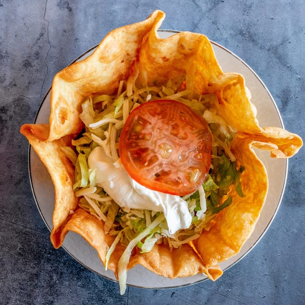 El Cabo Restaurant's taco salad in a crispy fried tortilla bowl with lettuce, tomato, and sour cream.