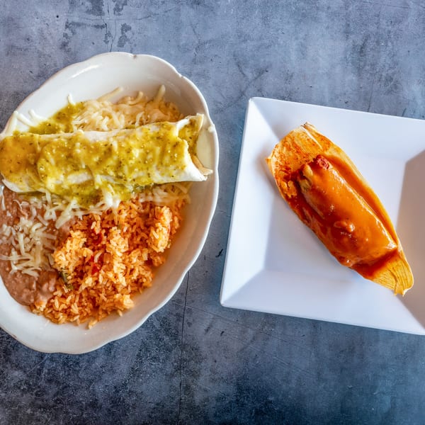 A plate of green chile enchiladas with rice and beans, and a tamale on a separate plate.