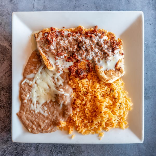 El Cabo Restaurant's Mexican dish with chicken, chorizo, rice, and refried beans on a white plate.