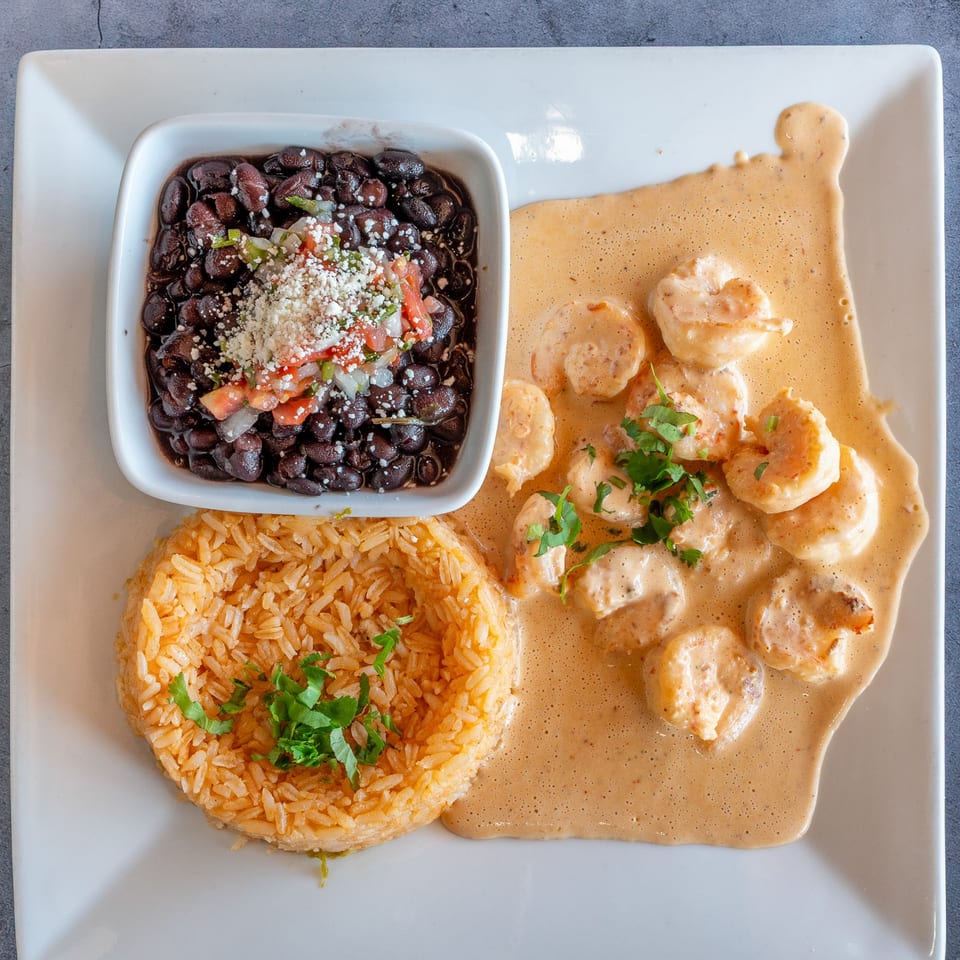 El Cabo Restaurant's creamy shrimp dish with black beans topped with pico de gallo and rice.